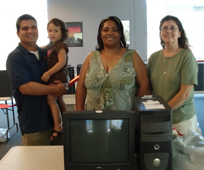 Sofie Rodriguez held by her father, Fernando Rodriquez, was the youngest winner of a computer in the giveaway conducted by St. Mary's County Library recently. With her are Faith Gross and Debra Webster, two other winners present at the drawing. Their names were drawn from thousands who entered hoping to win one of the 20 refurbished computers donated by SMARTCO and the 6 MP3 players donated by Best Buy.