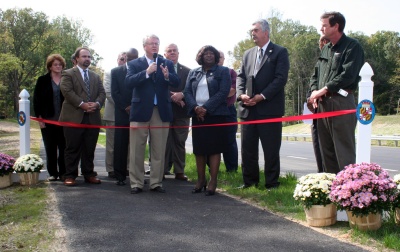 Commissioner Gary V. Hodge, surrounded by Commissioners Reuben B. Collins, II, Samuel N. Graves, Jr., and Edith J. Patterson, speaks about the benefits of traveling on the improved Middletown Road. County Administrator Paul Comfort, Charles County Government staff, and representatives from contracting companies that worked on the Middletown Road Phases 1B1, 1B2, and 2 projects, also participated in the ribbon-cutting event. (Photo: Crystal Hill)