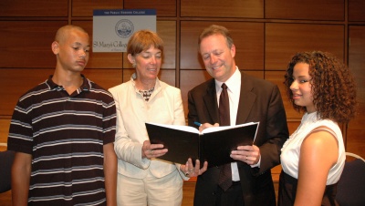 Superintendent, Dr. Michael J. Martirano, signs a memorandum of understanding between SMCPS and St. Mary’s College of Maryland at a ceremony with Dr. Jane Margaret O’Brien (left), president of SMCM, and two Fairlead Academy students, Shawn Briscoe of Lexington Park (far left), and Larissa Briscoe (far right) of Park Hall. The memorandum establishes a commitment of the college’s resources and facilities to Fairlead Academy students and alumni in coming years. (Submitted photo)
