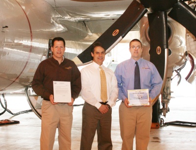 (L-R) Todd McGuire, Mike Conceicao, and Jesse McCormick, of La Plata-based Tech Wizards, stand in front of the Navy E-2C Hawkeye aircraft. McCormick and McGuire were recognized by NAVAIR for their work on the E-2C program. (Submitted photo)