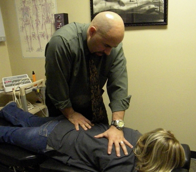 Jay Lipoff demonstrates chiropractic tecqniques on one of the people working in the office, Jen Klesch.