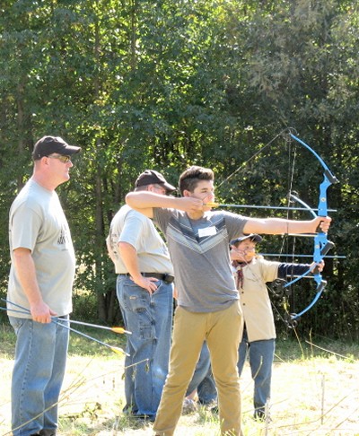 Volunteer Rich Walker (left) instructs Alec Cabrera (right foreground) in the finer points of archery at the seventh annual Wildlife Adventure Day in Newburg, Charles County. (Submitted photo)