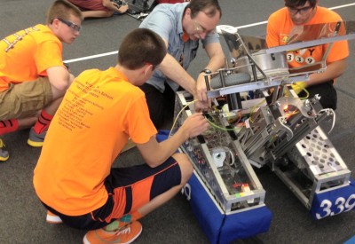 Commonwealth Virginia Governor's School students and their mentor, Bob Brown - a computer scientist supporting Naval Surface Warfare Center Dahlgren Division (NSWCDD) as a contractor - work to reset the student-built robot known as Kilroy before a match at "Duel on the Delaware 2013". The National Defense Education Program sponsored high school team and its allies did not make the top three among 34 high schools in the competition. However, the team's technology skills are number one, say their NSWCDD mentors. (U.S. Navy photo by James R. Smith/Released)