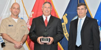 Michael Pompeii (center) holds the Dahlgren Award plaque after he was presented the award and congratulated by Capt. Brian Durant, Naval Surface Warfare Center Dahlgren Division (NSWCDD) Commander, and Dennis McLaughlin, NSWCDD Technical Director at the command's annual Honor Awards Ceremony. Pompeii was commended for shaping Dahlgren's Chemical, Biological and Radiological Defense capabilities which have expanded NSWCDD's enduring capabilities to research, develop and field revolutionary systems of systems to the Sailor, Department of Defense and the nation. (U.S. Navy photo/Released)