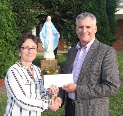 John Slaughter, president of St. Mary's Council #1470 Knights of Columbus Charities, Inc., presents a check to Linda Miedzinski, principal of Mother Catherine Academy, at the school's Mechanicsville campus. The independent Catholic school will open in July.