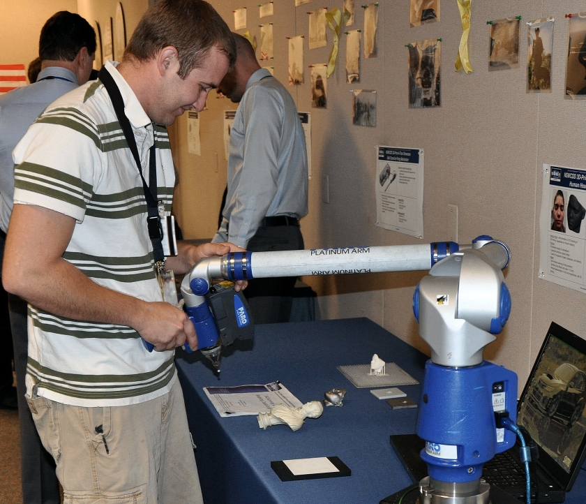 Naval Surface Warfare Center Dahlgren Division (NSWCDD) instrumentation engineer Kevin Streeff demonstrates how the 3D ScanArm scans objects and creates digital models for printing. A digital model of the scanned bust is shown on the computer screen during the command's December 2015 Print-A-Thon. The reality of 3D Printing - also known as additive manufacturing - is expanding across the Navy's science and engineering community via Naval Surface Warfare Center Dahlgren Division (NSWCDD) and Combat Direction Systems Activity (CDSA) Dam Neck. (U.S. Navy photo by Luefras Robinson/Released)