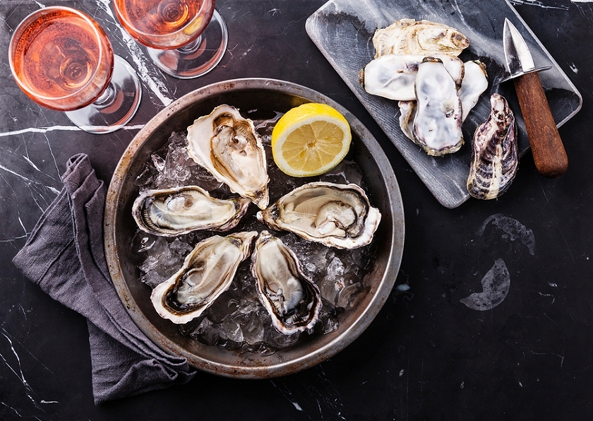 Opened oysters with lemon and wine. (Stock photo)