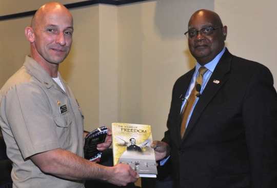 DAHLGREN, Va. - Capt. Brian Durant, Naval Surface Warfare Center Dahlgren Division (NSWCDD) commander, presents the Dahlgren history book, "The Sound of Freedom," to Dr. William Bundy, Gravely Naval Warfare Research Group director, at the 2016 Black History Month Observance, Feb. 11. "The research and development progress that was shared with me on the railgun and directed energy systems was very reassuring," said Bundy, a U.S. Naval War College professor who toured NSWCDD electromagnetic railgun and directed energy facilities after inspiring a military and civilian audience with his keynote speech at the observance. "Those capabilities will certainly deliver advantages for our maritime forces. It was absolutely encouraging to witness first-hand the remarkable effort and work that is continuing today at Dahlgren." (U.S. Navy photo by Barbara Wagner/Released)