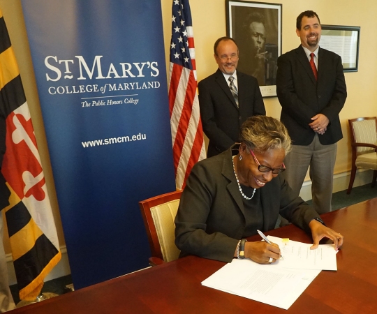 St. Mary's College of Maryland signs agreement with Aruban Minister of Education and Family Policy Michelle Hooyboer-Winklaar (not pictured) via skype. (Front, seated) Dr. Tuajuanda Jordan, president, St. Mary's College of Maryland (back, standing L-R) Michael Wick, provost, dean of faculty; John Barber, transfer coordinator.