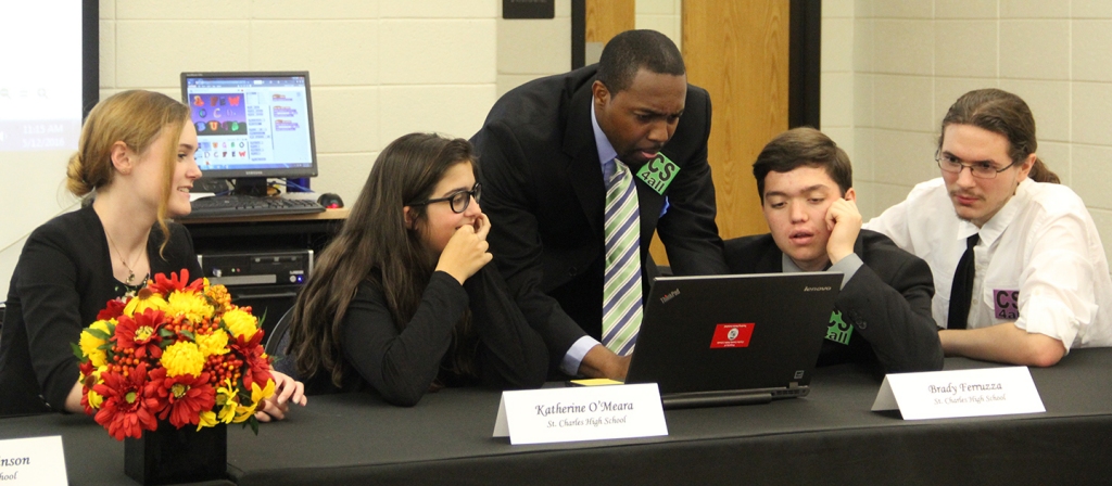 Terence Stone, who teaches computer science at St. Charles High School, goes over last minute details on a presentation made by Alex Atkinson, left, Kate O'Meara, Brady Ferruzza and Robert Smith at a CS4All event hosted earlier this year by Charles County Public Schools. (Submitted photo)