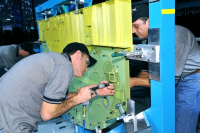 Spirit AeroSystems employees install the first piece of the P-8A Poseidon into a holding fixture during a ceremony at the factory Dec. 11. Spirit will build the fuselage and then ship it to Boeing Commercial Airplanes in Renton, Wash., where it will receive the wings and assemblies. This is the first of five test planes that will be built for the Navy. (Photo provided by Spirit AeroSystems)