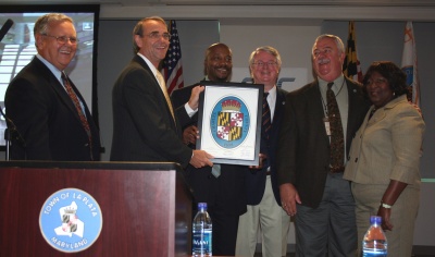 The Charles County Commissioners present a County Seal to Thomas G. Baybrook, SAIC Senior Vice President & General Manager, Defense Maritime Solutions Business Unit, in recognition of the company opening its newest office in La Plata.