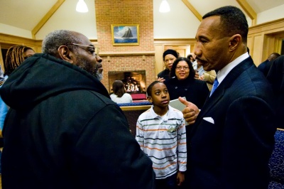 Nine-year-old Robert Gaskin, a third grader at Ridge Elementary School, looks on admiringly as former Md. Congressman and president of the NAACP Kweisi Mfume speaks to former St. Mary's County NAACP president Alonzo Gaskin, Robert's grandfather, during the annual Carter G. Woodson Lecture yesterday evening at St. Mary's College of Maryland. (Photo: Frank Marquart)