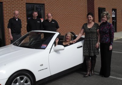 In car: raffle winner Mrs. Toni Hoover of Owings. Men standing (L-R): Family Mercedes BMW Technician Robert Gill, Family Mercedes BMW Technician Charlie Shaffer, and Family Mercedes BMW Co-Owner/Master Technician Dwayne Crawford. Ladies standing: Family Mercedes BMW Co-Owner/Manager Wendy Crawford handing keys to winner, Mrs. Kelly Chambers, CEO of Calvert County United Way. (Submitted photo)