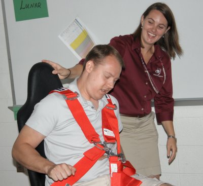 Justin Meeder, an Earth and space science teacher at Westlake High School, pictured left, demonstrates an orbital spin in a Barany chair with the assistance of Melissa Peterson, an aerospace education specialist with the Space Foundation, pictured right, during the Space Discovery Institute’s Biological and Physical Research session held July 26-30 at Theodore G. Davis Middle School. Participants volunteered to take a turn spinning blindfolded in the chair, which simulates spatial disorientation effects. (Submitted photo)