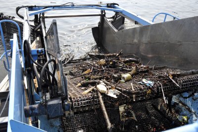 D.C. Water, the District of Columbia's water and sewer utility, operates two trash skimming boats that collect surface waste from the Anacostia on a daily basis, moving it to conveyor belts on the shore and into dumpsters. (News21 Photo by Jason Lenhart)