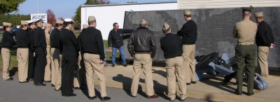 U.S. Naval Academy Midshipmen are briefed at the NSWC Dahlgren Potomac River Test Range on Nov. 19 during a tour that also featured the Electromagnetic Railgun, Integrated Warfare Systems Laboratory and the Human Performance Lab. The 20 midshipmen and four instructors toured the gun line where testing has been conducted since 1918 and stepped into laboratories designed to shape the Navy's future. "It's interesting to see how technologies are developed and applied to the actual Fleet in present and future operations - from the 1950s to Railgun," said Midshipman First Class Ben Bennett. U.S. Navy photo by Jon Dachos, NSWC Dahlgren Division Human Systems Integration Command Center Design Lead Engineer.