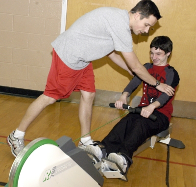 Esperanza Middle School Physical Education Teacher William Plotner, standing, explains how to use the rowing machine to eighth-grader Austin Kraese. (Submitted photo)