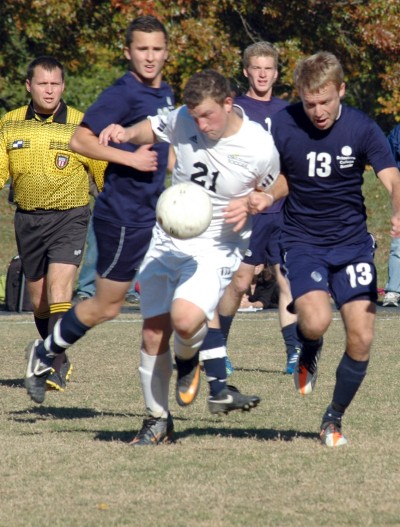 CSM student athlete Kyle Toepfer (No. 21) tries to break away from Schoolcraft College players during the North Central District Championship game Nov. 5th at the La Plata Campus. (Photo: Angel Torres and Diane Payne)