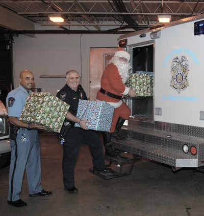 Santa and his helpers from the Corrections Division load gifts in preparation for his visit to their adopted family.