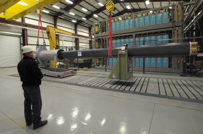 Gary Bass, from the Naval Surface Warfare Center in Dahlgren, Va., uses a crane to maneuver a 32-MJ version of the Office of Naval Research-funded Electromagnetic Railgun (EMRG) prototype into place for government evaluation. The EMRG is a long-range weapon that launches projectiles using electricity instead of chemical propellants and is under development by the Department of the Navy for use aboard ships. (U.S. Navy photo by John F. Williams/Released)