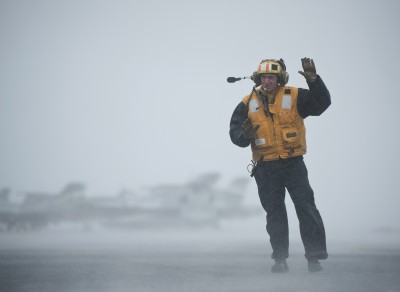 PACIFIC OCEAN (May 7, 2012) Aviation Boatswain's Mate (Handling) 2nd Class Jathan Lane directs the movement of aircraft during foul weather on the flight deck aboard the Nimitz-class aircraft carrier USS Carl Vinson (CVN 70). Carl Vinson and Carrier Air Wing (CVW) 17 are deployed to the U.S. 7th Fleet area of operations. (U.S. Navy photo by Mass Communication Specialist 2nd Class James R. Evans/Released)