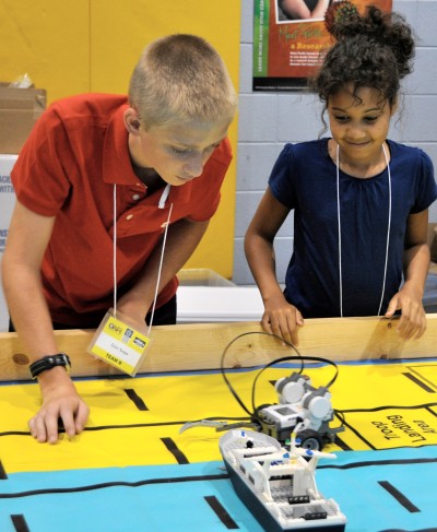 Science, technology, engineering and mathematics (STEM) Summer Academy students rescue a ship in distress with a robot they programmed. They are among over 100 middle school students working on STEM summer camp activities and projects impacting simulated naval robotic missions June 25-29. Navy officials anticipate that Virginia Demonstration Project Summer Academy students may one day use their STEM skills at Naval Warfare Center laboratories to design future technologies supporting U.S. warfighters and America's homeland defense and security. (U.S. Navy photo by John Joyce/Released)