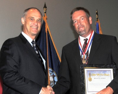Robert Nichols - a Naval Surface Warfare Center Dahlgren Division (NSWCDD) NSWCDD Secretary of Defense Global War on Terrorism (GWOT) Medal recipient -is congratulated by NSWCDD Technical Director Carl Siel at a July 27 Dahlgren, Va., ceremony. Nichols was instrumental in the successful operation of a counter-IED system while serving as a senior in-theater technical lead in support of Operation New Dawn under the Commander of United States Forces - Iraq.