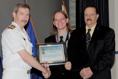 Andrew Watkins - a Naval Surface Warfare Center Dahlgren Division (NSWCDD) Secretary of Defense Global War on Terrorism (GWOT) Medal recipient -is congratulated by Naval Sea Systems Command Executive Director Brian Persons (right) and NSWCDD Commander Capt. Michael Smith at a July 27 Dahlgren, Va., ceremony. Watkins was instrumental to the successful operations of a counter-IED system while serving as in-theater technical lead in support of Operation New Dawn under the Commander of United States Forces - Iraq.