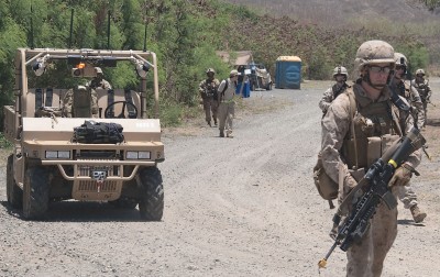 A Ground Unmanned Support Surrogate (GUSS) follows the beacon signal of Pfc. Dylan Hoffstatter (right), grenadier for 3rd Platoon, Company G, 2nd Battalion, 3rd Marine Regiment, during a Rim of the Pacific exercise where GUSS was evaluated in 2010. More than 150 U.S. Marines and a team of Navy civilian engineers continued testing GUSS and a myriad of unmanned systems at a Fort Pickett, Va., experiment from July 23 to Aug. 7, 2012. They tested new ways of using unmanned vehicles to increase situational awareness and decrease Marines' exposure to improvised explosive devices. (U.S. Marine Corps photo by Lance Cpl. Ronald W. Stauffer/Released)