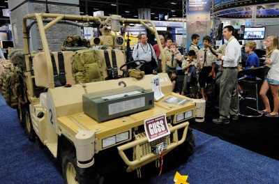 Brent Azzarelli, Naval Surface Warfare Center Dahlgren Division Chief Robotics Engineer, explains the Ground Unmanned Support Surrogate (GUSS) at an Association for Unmanned Vehicle Systems conference. Azzarelli, a team of Navy civilian engineers, and more than 150 U.S. Marines tested new ways of using unmanned vehicles, including GUSS, to increase situational awareness and decrease Marines' exposure to improvised explosive devices during an experiment held at Fort Pickett, Va., from July 23 to Aug. 7. (U.S. Navy photo by John F. Williams/Released)