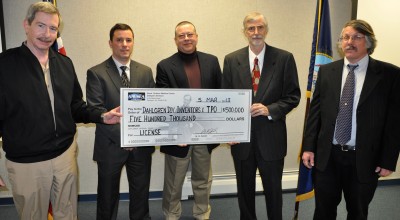 Naval Surface Warfare Center Dahlgren Division Commander Capt. Michael Smith and four NSWCDD inventors hold a symbolic check representing $500,000 in exclusive patent licensing fees at a March 5 ceremony. NSWCDD received $100,000 per patent – the largest upfront fees in the Navy's history – from Kismet Mgmt Fund LLC, for the licensing of five patents. The employee-inventors (left to right) Larry Fontenot, Danny Synan, Mike Masters (ret.) and Paul Werme were joined by their family members and command leadership at the event. Lonnie Welch, a Ohio University professor named as a co-inventor of all five patents, was not in attendance. U.S. Navy photo by John Joyce (Released).