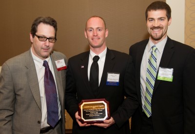 BOSTON, Mass. - Navy geographer Matthew Page holds the plaque presented to him by Careers & the disABLED Magazine Editor Larry Jaffee, left, and Robert Bills, Naval Surface Warfare Center Dahlgren Division Disruptive Technologies Branch head, at the magazine's 21st Annual Awards reception and dinner. The Navy announced May 22 that Page - a wounded warrior - received the magazine's 2013 National Employee of the Year award for outstanding achievement. The former Army captain's leadership and experience as a Navy civilian led to the development of several innovative systems to aid warfighters in combat. He was also recognized as a strong and successful volunteer advocate for wounded warriors and their families.