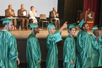 Graduates of CSM’s Juvenile Offenders Building Skills (JOBS) program turn and give a shout-out to their families during the opening minutes of the May 9 graduation ceremony in La Plata as onstage guests, from left, CSM President Dr. Brad Gottfried, Board of Trustees Chair Joseph Austin Slater Jr., Charles County Commissioner President Candice Quinn Kelly and JOBS Project Director Robert Manley, look on.