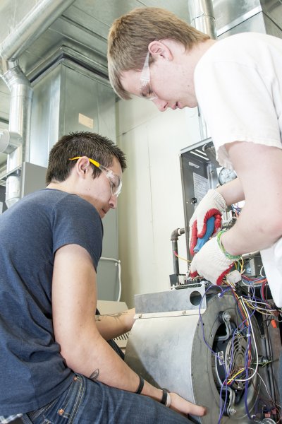 CSM JOBS students Casey Bridgett of Mechanicsville, right, and Brandon Swinson of Waldorf check the connections on a training air-conditioning unit during HVAC training at CSM’s Center for Trades and Energy Training (CTET).