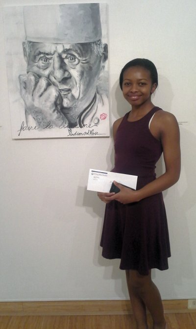 Madison Ross standing next to her award-winning work entitled “Chef: The French Kind.” Ross’ piece was described by juror Moriah Morgan as “not just a picture, but a story.” (Submitted photo)