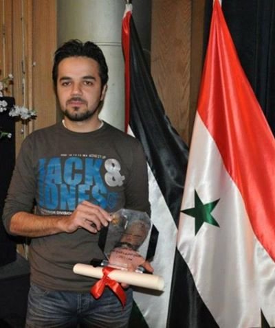 Ahmad Beetar displays an award for an initiative he started known as Eye on Aleppo, which focuses on cultural events, local volunteerism and development issues in the Syrian city. (Photo courtesy of Ahmad Beetar)