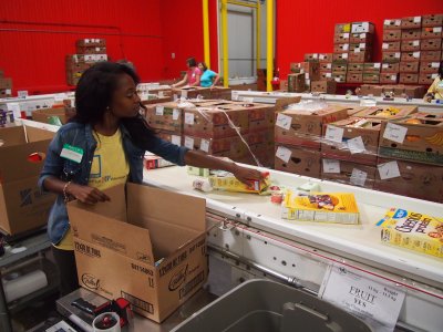 Janet Addo, 25, a first-time volunteer with the Maryland Food Bank, sorts food items for distribution in Baltimore. Sept. 30. (Photo: Madeleine List)