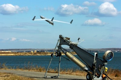 DAHLGREN, Va. - A Scan Eagle unmanned aerial vehicle (UAV) launches from the Naval Surface Warfare Center Dahlgren Division (NSWCDD) Potomac River Test Range. NSWCDD scientists and engineers demonstrated how the science of integration makes surface warfare systems interoperable with unmanned systems - including Scan Eagle UAVs - during a surface warfare integration experiment here, Sept. 29, 2014. Surface warfare officers evaluating the technology joined civilian technologists at the event to prove the Navy can bridge interoperability gaps known as the interstitial space between complex system-of-systems. "Scan Eagle has been deployed on guided missile destroyers for years to provide persistent electro-optical and infrared surveillance," said Cmdr. Marc Williams, surface warfare tactical action officer for the experiment. "It has been used for Naval Surface Fire Support spotting to walk gun rounds onto an enemy target, but not in an automated fashion like in this experiment." (U.S. Navy photo by John Williams/Released)