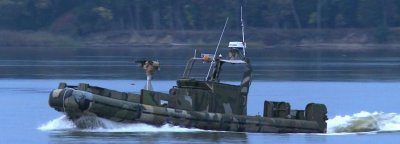 DAHLGREN, Va. - An autonomous unmanned surface vehicle (USV) transmits real-time targeting data to an Aegis weapon system that engaged a target on the Potomac River Test Range with the MK34 5 inch/62 caliber gun weapon system during a surface warfare integration test Sept. 29. The fall of shot - observed by a Scan Eagle Unmanned Air Vehicle (UAV) optical sensor - was used to provide gun targeting corrections immediately to the MK160 gun weapon system operator. Naval Surface Warfare Center Dahlgren Division engineers demonstrated how the science of integration makes surface warfare systems interoperable with USVs and UAVs during the experiment. (U.S. Navy photo by Patrick Dunn/Released)