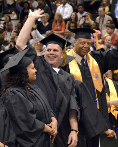 James McKissick, 47, of Waldorf, earned an associate degree in accounting with high honors and is shown fourth from left, waving to friends, family and tutors during the May 2014 Commencement Ceremony.