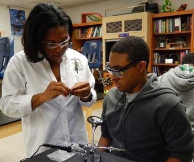 Naval Surface Warfare Center Dahlgren Division systems safety engineer Brandie Jackson mentors an elementary school student in a science, technology, engineering and mathematics (STEM) project. A month after she was honored by the Society of Women Engineers with its 2014 Member at Large Outreach Award in October, Jackson - reflecting on Thanksgiving and the outreach award - said, "I am thankful for the chance to mentor and encourage school age youth, their parents, and the community."