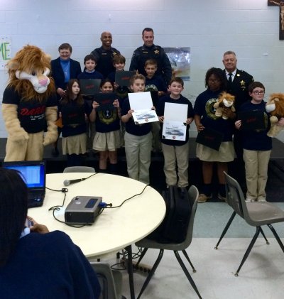 Pictured above: DAREN, Sister Carolyn Marie, DFC A. Mitchell, DFC M. Robshaw, Sheriff Mike Evans, and Our Lady Star of the Sea 5th Grade Graduating Class.