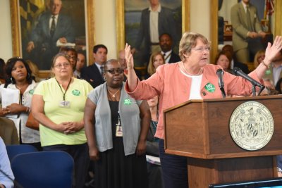 AFSCME representative Sue Esty testifies to the Board of Public Works with some of the prison personnel employees proposed for layoff standing behind her. (Photo: Governor's Office)