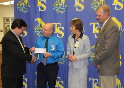 Chris Conway, left, president and chief executive officer for Educational Systems Federal Credit Union, presented Thomas Stone High School math teacher Daniel Weiss, second from left, with a $1000 check on Nov. 9 to recognize him as the overall winner in the credit union’s Tips and Tools for Back to School campaign held earlier this school year. Charles County Public Schools Superintendent Dr. Kimberly Hill, second from right, and Stone Principal Michel Meiser, right, were also present during the Nov. 9 check presentation.