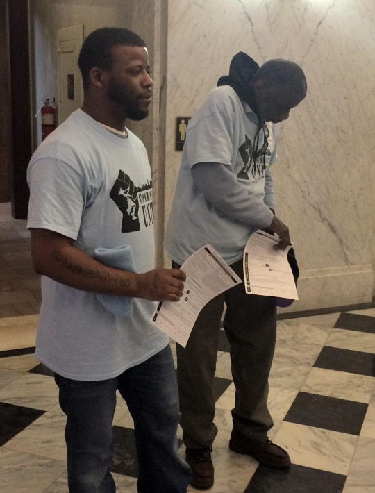 Convicted felon and Communities United member Marcus Toles, left, clutches a voter registration form after the Maryland Senate passed an override of a veto that would provide voting rights to felons on probation or parole, on February 9, 2016. (Photo: Leo Traub)