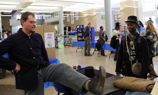 Civil War re-enactor Robert Bowser, left, shows visitors to the History, Industry, Technology and Science Expo what sort of shoes Civil War soldiers wore.