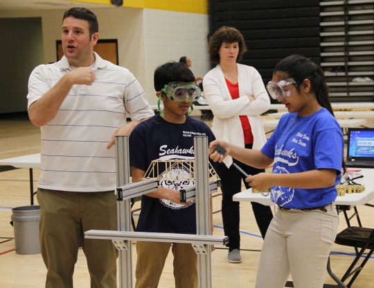 Milton M. Somers Middle School was named the overall middle school winner at the Charles County Public Schools secondary Mathematics, Engineering and Science Achievement (MESA) competition held March 31 at North Point High School. Student teams compete in competitions that test their abilities in mathematics, engineering and science. Pictured are Somers seventh grader Sahil Patel, front left, and Aastha Patel, a Somers sixth grader, as they compete in the basswood bridge challenge at the event. They received first place among competing middle school teams in the basswood challenge. Also pictured are Adam Todd, back left, an instructional resource teacher with Charles County Public Schools who served as a MESA judge, and Christine Kernozek, back right, an instructional specialist for Charles County Public Schools who served as a MESA judge.