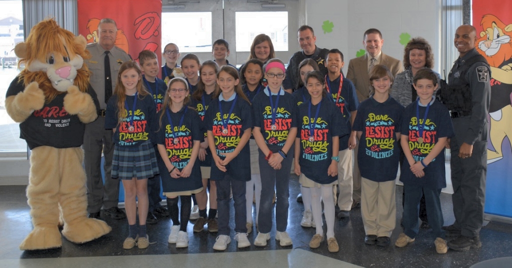 above: DAREN, Sheriff Mike Evans, DFC M. Robshaw, Retired Sgt. Mike Bomgardner, Mrs. Shaw, DFC A. Mitchell, and "Our Lady Star of the Sea" 5th Grade Graduating Class. (Submitted photo)