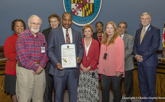 Pictured left to right: Commissioner Amanda M. Stewart, M.Ed. (District 3); Harry Kriemelmeyer, Jr., Christmas in April Charles County; Commissioner Ken Robinson (District 1); Alvin Stewart, Christmas in April Charles County; Sandie Branan, Christmas in April Charles County; Commissioner Vice President Debra M. Davis, Esq. (District 2); Colleen Longhi, Christmas in April Charles County; Commissioner Bobby Rucci (District 4); and Commissioner President Peter F. Murphy.